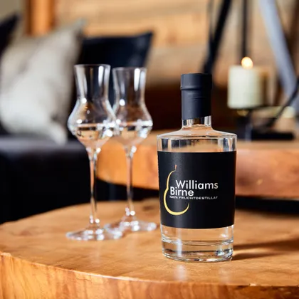 Williams Birne Fruchtdestillat mit zwei Schnapsgläsern auf einem Holztisch