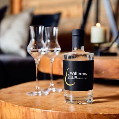 Williams pear fruit brandy with two schnapps glasses on a wooden table