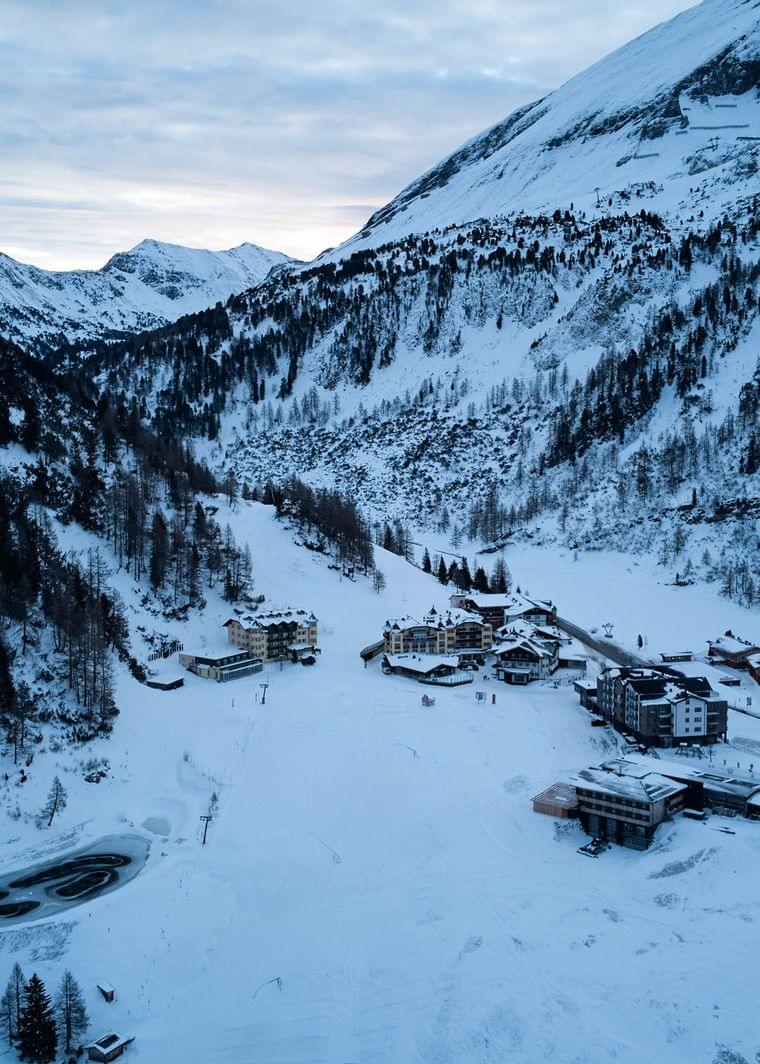 Snow-covered alpine village nestled in a mountain valley during winter