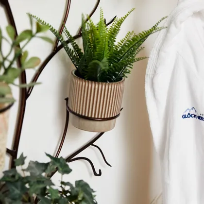 White bathrobe with Glocknerin logo hanging next to wall-mounted plants