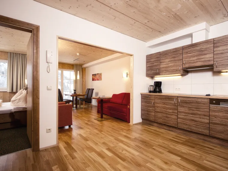 Modern holiday apartment with wood flooring, kitchenette and dining area