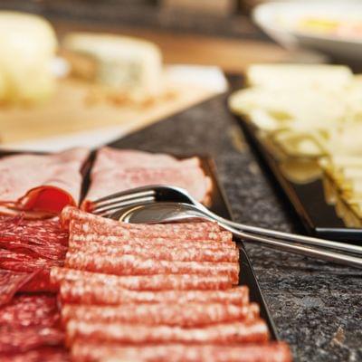 Variety of cold cuts and sliced cheese on trays for breakfast or brunch