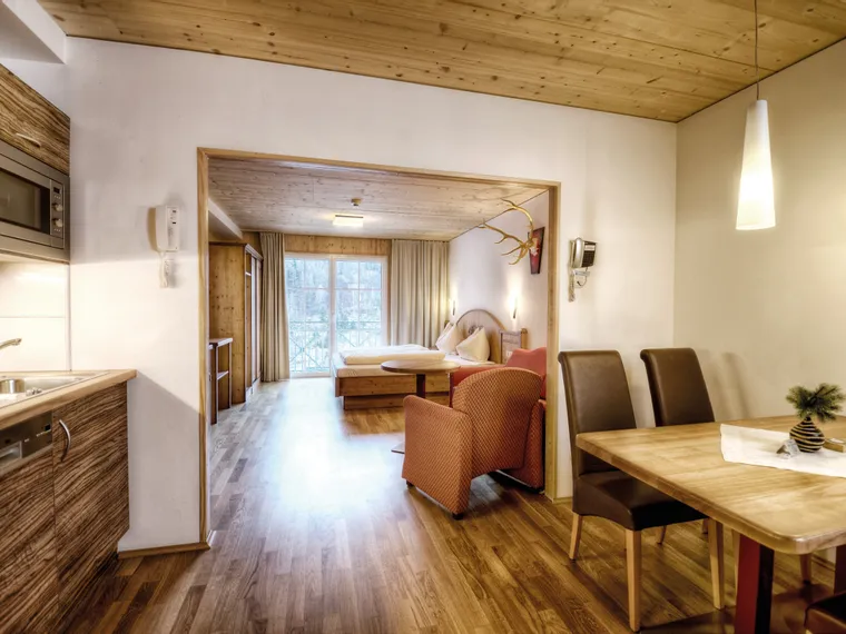 Gemütliches Appartement mit Holzmöbeln, Küchenzeile, Essbereich und Schlafzimmer mit Tageslicht