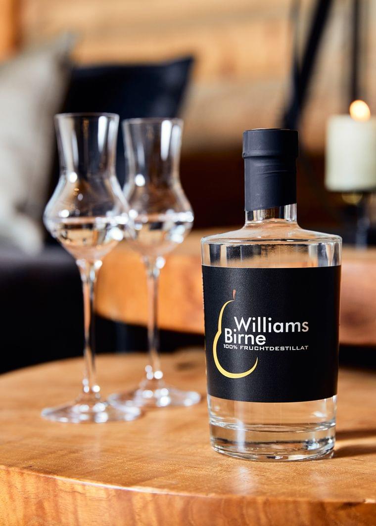 Williams Birne Fruchtdestillat mit zwei Schnapsgläsern auf einem Holztisch