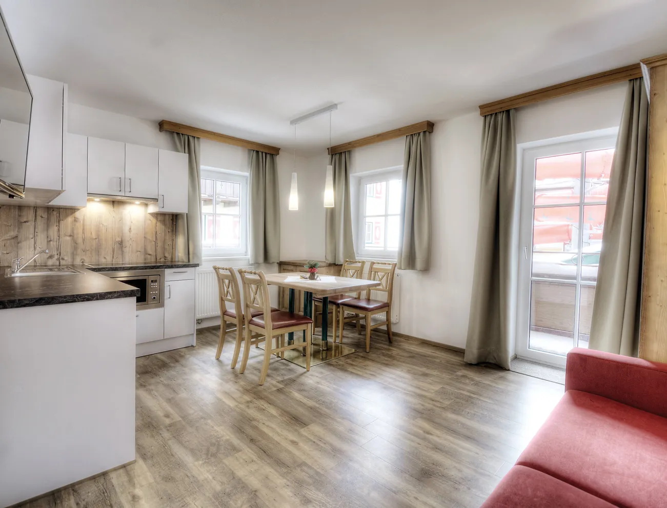 Moderne Ferienwohnung mit offener Küche, Esstisch und Balkonzugang