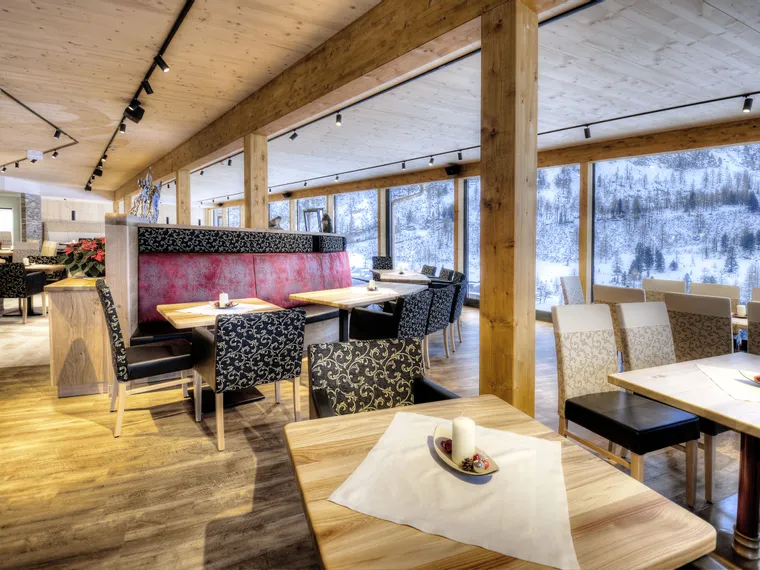 Modern restaurant with wood interior and panoramic view of snowy mountain landscape