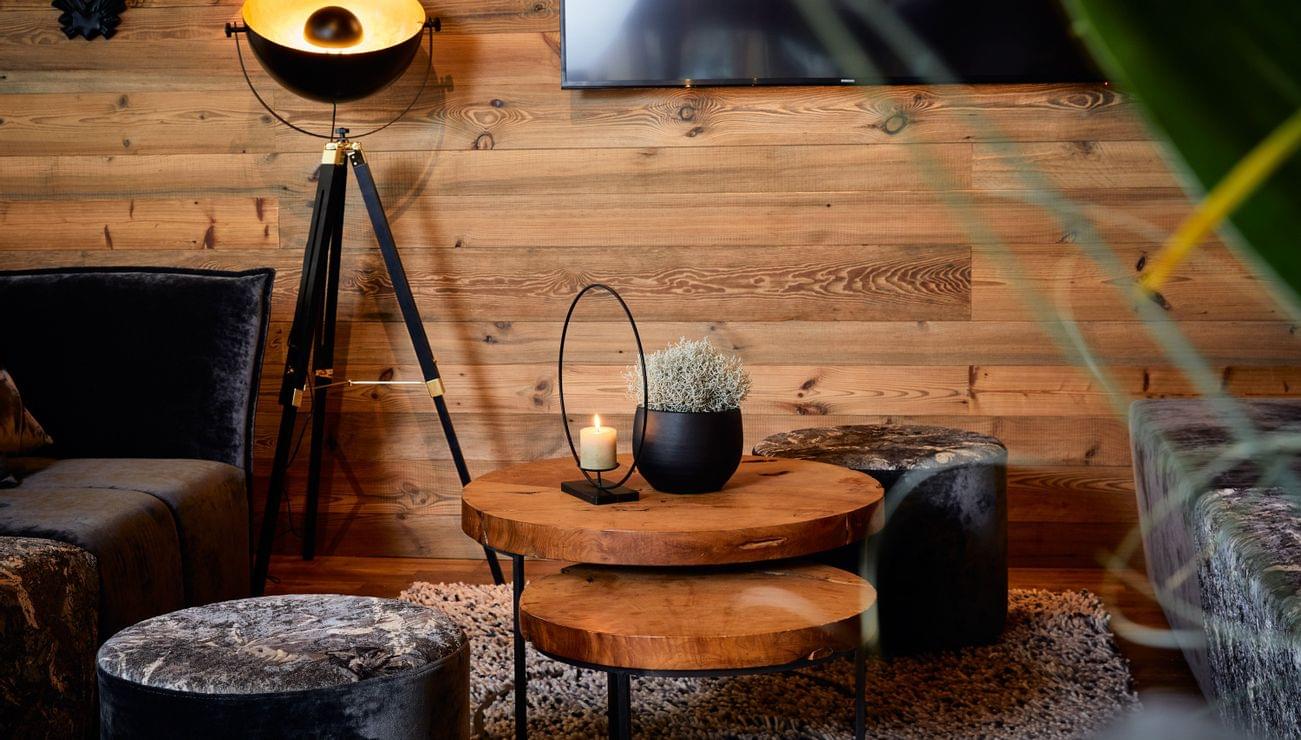 Cozy living room with rustic wood coffee tables, velvet furniture and tripod floor lamp