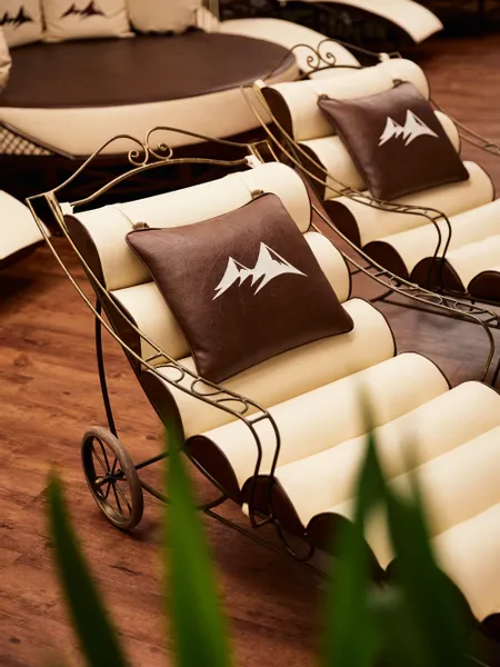 Elegant spa lounge chairs with brown mountain-logo cushions on wood flooring