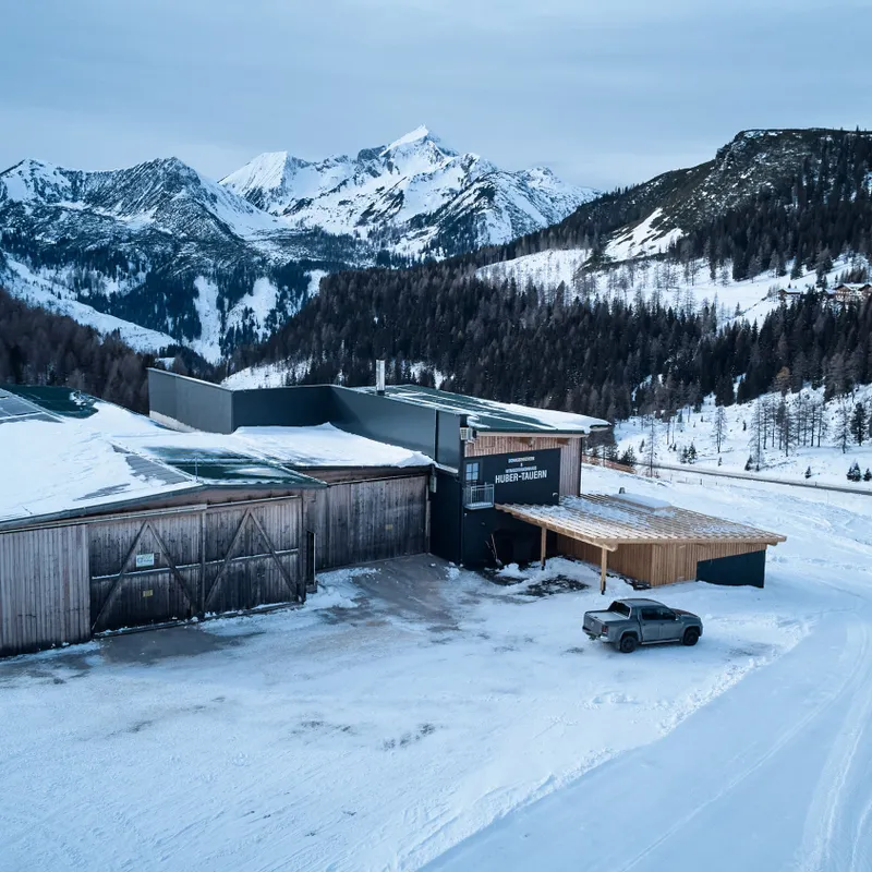 Snow-covered alpine building with solar panels in Austrian mountains