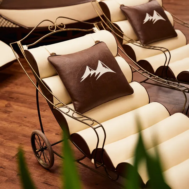 Elegant spa lounge chairs with brown mountain-logo cushions on wood flooring