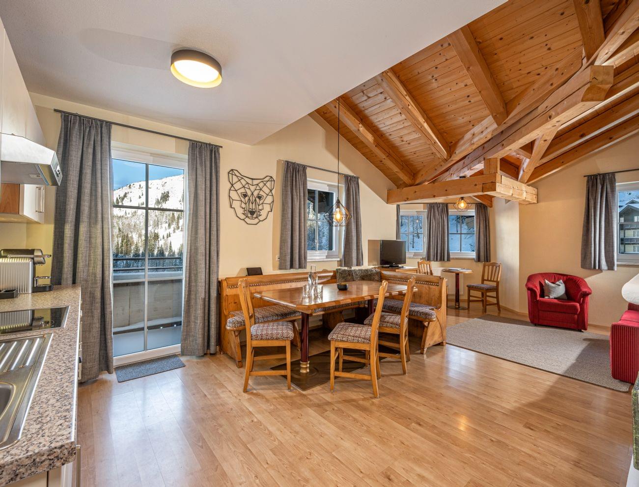 Cozy alpine apartment with wooden ceiling, dining area, and mountain view
