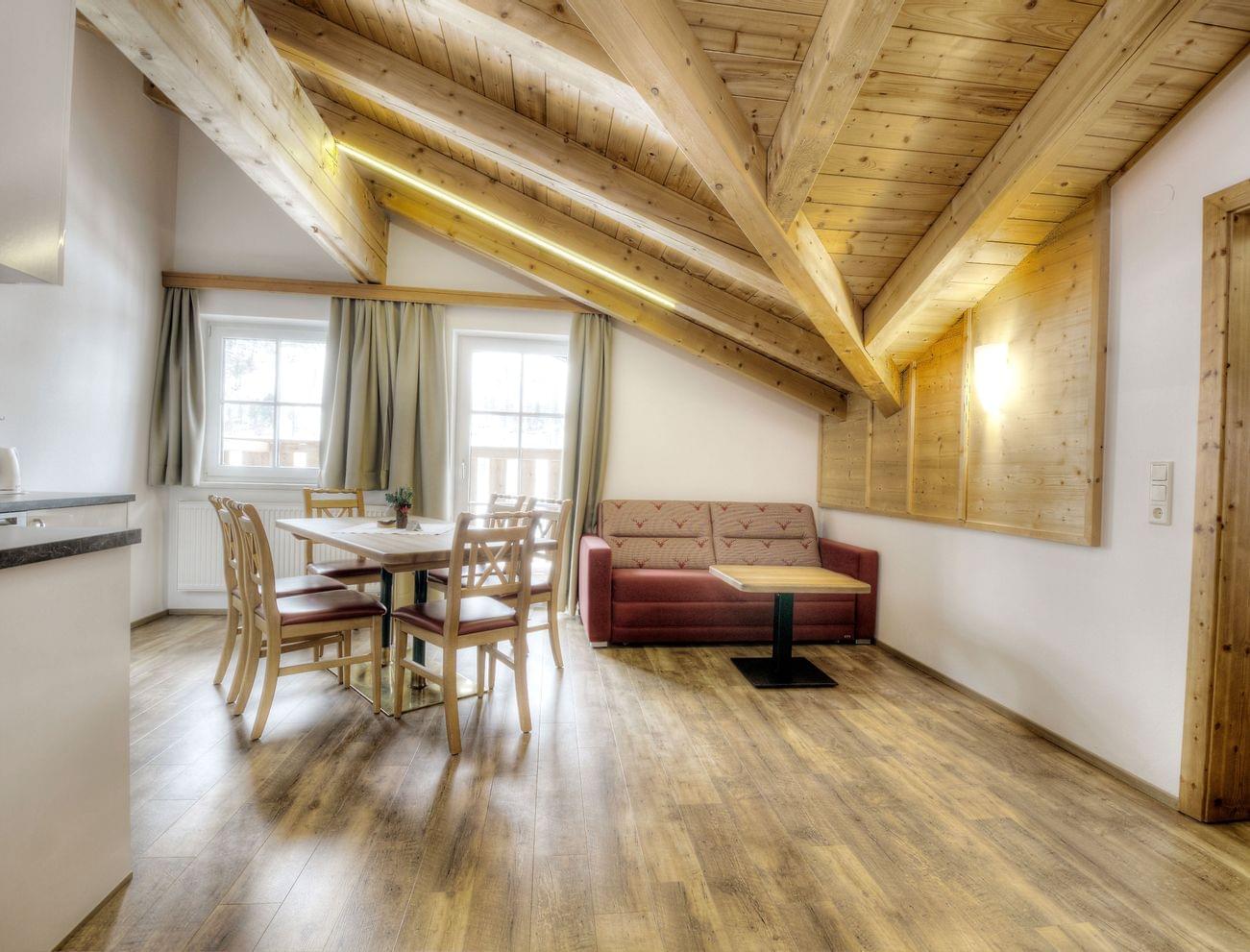 Cozy apartment with wooden beam ceiling, dining area and red sofa