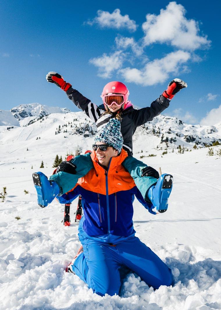 Happy family playing in snow on ski holiday in the mountains