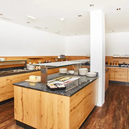 Modern breakfast buffet with wooden counters and assorted food items