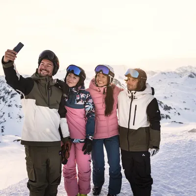 Gruppe von Freunden macht ein Selfie beim Skifahren in verschneiten Alpen