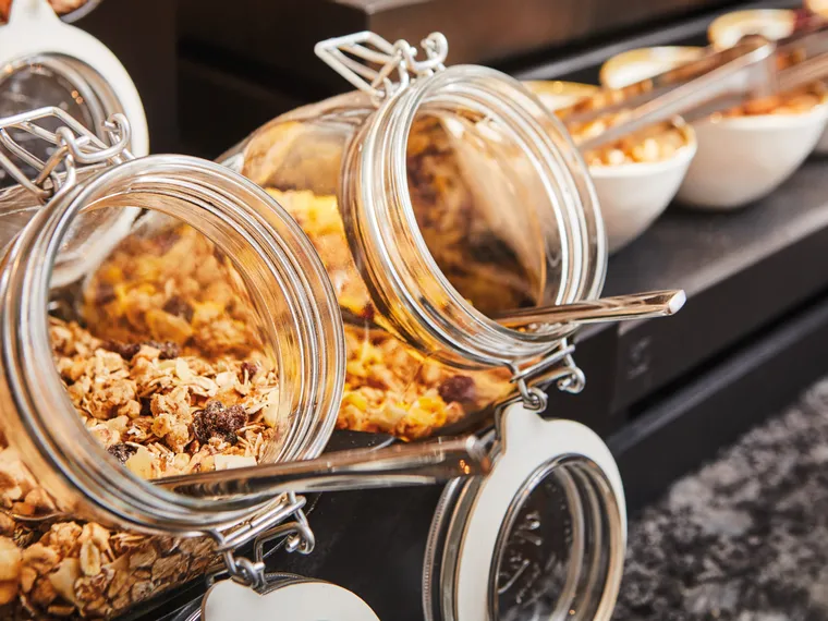 Open glass jars filled with granola at breakfast buffet