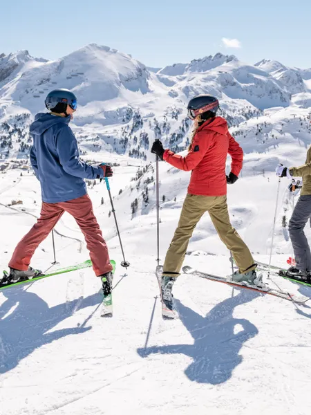 Group of skiers on snowy mountain slope with panoramic alpine view