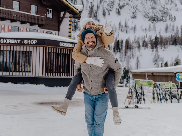 Happy couple at ski resort in snowy mountain setting in winter