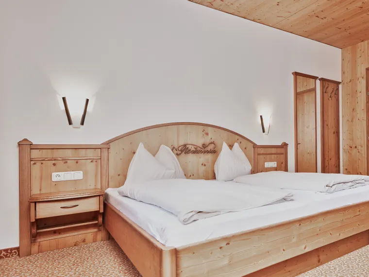 Cozy hotel room with double bed and light wooden furnishings