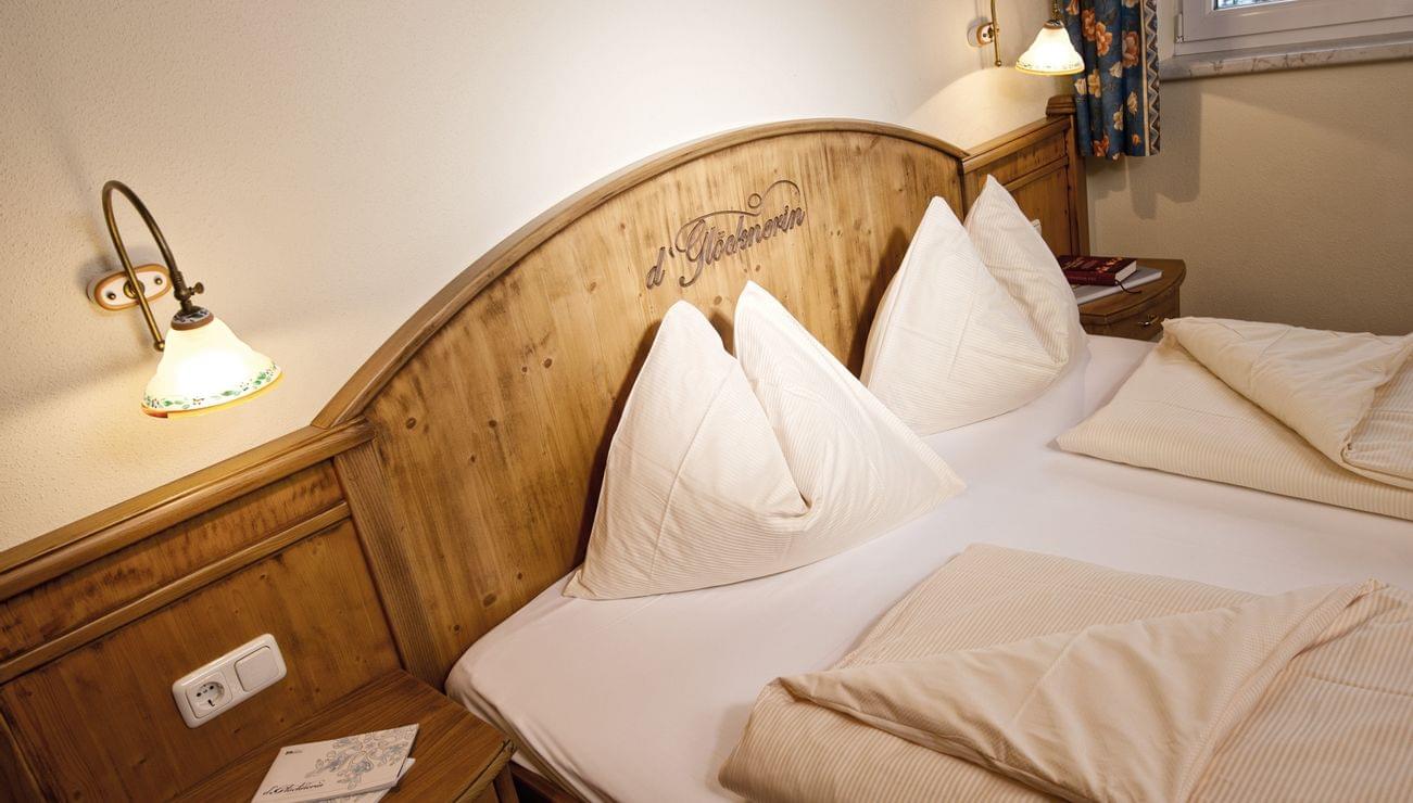 Gemütliches Hotelzimmer mit Doppelbett, Holzrahmen und warmer Beleuchtung